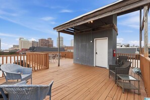 A rooftop deck with outdoor seating, a covered area, and a city skyline in the background. - Soothing 1-bedroom apartment with AC in Birmingham (Birmingham)