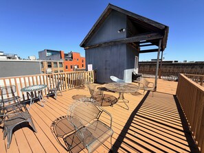 A rooftop deck with outdoor seating, a covered area, and a view of surrounding buildings. - Soothing 1-bedroom apartment with AC in Birmingham (Birmingham)