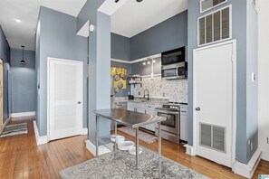 A modern kitchen with stainless steel appliances, a white door, and a patterned rug. - Soothing 1-bedroom apartment with AC in Birmingham (Birmingham)