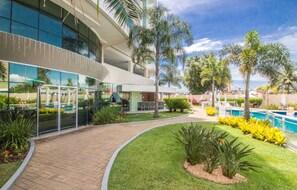 Et moderne hotel med pool, palmer og en velholdt have.