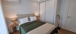 A bedroom with a bed, bedside lamps, a wardrobe, and a floor lamp. - Ondas Beach House
Designed for your natural living a few steps from the beach (Monte Gordo)