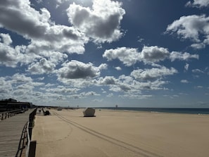 A beach with a wooden boardwalk, a large white sculpture, and a clear sky with clouds. - Ondas Beach House
Designed for your natural living a few steps from the beach (Monte Gordo)