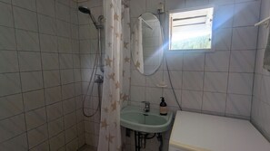 A bathroom with a shower, a sink, a mirror, and a window. - Historic Norwegian farmhouse in Telemark (Telemark)