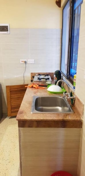 A kitchen with a stainless steel sink, a window, and a stove. - Bella Breeze2 - Diani Beach, Kenya (Diani Beach)
