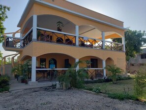 A two-story building with a balcony on the upper level, surrounded by greenery. - Bella Breeze2 - Diani Beach, Kenya (Diani Beach)