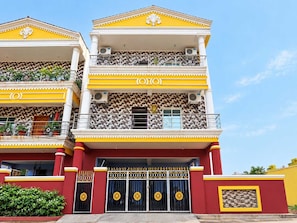 A multi-story building with balconies, a tiled facade, and a prominent entrance with a gate. - Classic Advik Cottage (Bhubaneshwar)