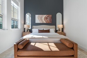 A bedroom with a large bed, two bedside tables with lamps, a wall-mounted artwork, and a window providing natural light. - Downtown Round Rock, Steps to Main St (Round Rock)