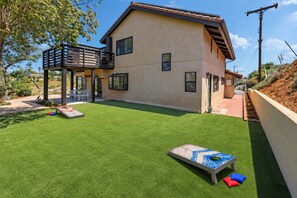 A house with a flat roof, a balcony, and a well-maintained lawn. - Hillview Ranch Retreat A/C Views 16+ guests (Fallbrook)