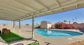 A covered outdoor swimming pool with a lawn area, a shed, and a fence. - Private Pool Oasis | Near Tempe Diablo Stadium (Phoenix)