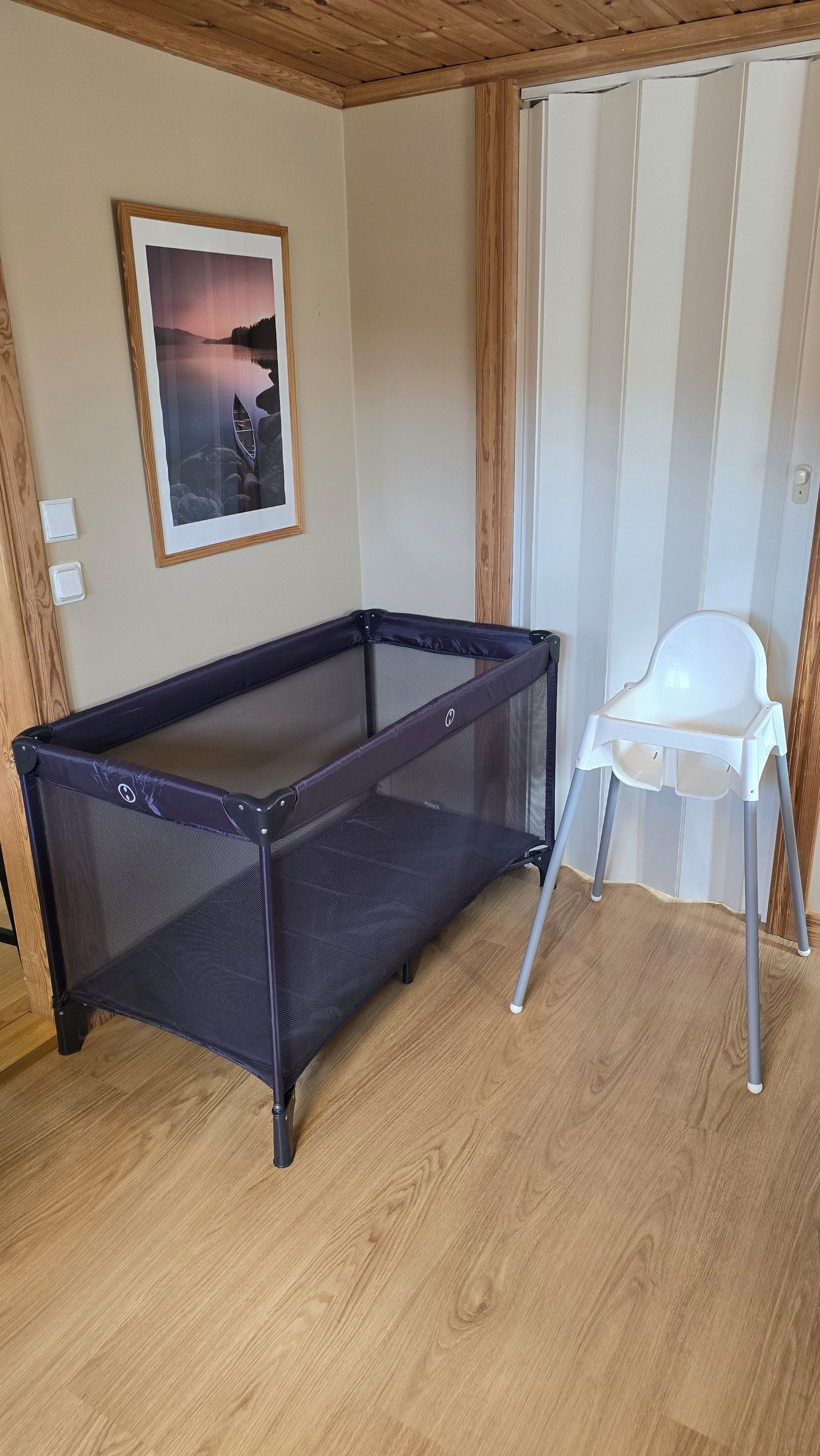Ein Zimmer mit Billardtisch, einem weißen Sessel und einem gerahmten Bild an der Wand.