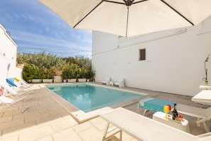 A pool area with lounge chairs, a table with drinks, and umbrellas. - Villa Escondida - Taviano (Taviano)