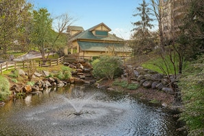 A house with a pond and a wooden bridge. - 2BR/2BA Smoky Mountains Resort Suite · Indoor Pool & Hot Tubs · Sleeps 8 (Sevierville)