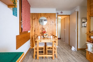A wooden dining table with chairs, a mirror, and a vase with flowers. - Le Montagnard - Vue Mont Blanc - Pistes (Landry)