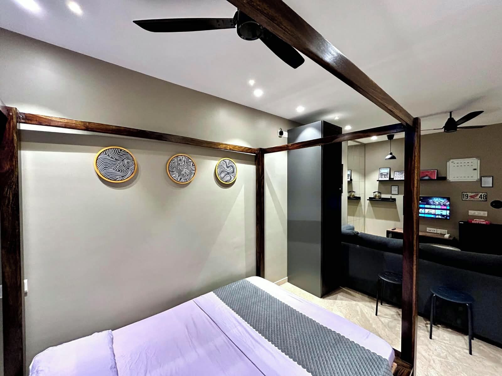 A modern hotel room with a bed, a desk, and a television.