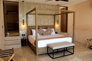 A four-poster bed with a wooden frame and a bench at the foot, a wooden bench at the foot of the bed, and a wooden chair to the left. - Estrena casa boutique • Mérida Centro • 5 habs (Mérida)