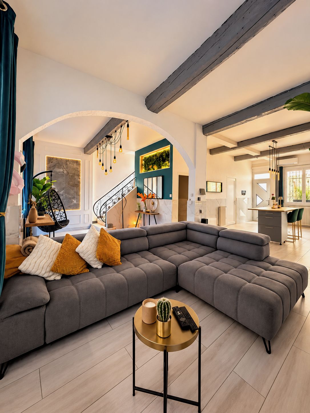 A modern living room with a sectional sofa, a round coffee table, and a staircase leading to an upper level.