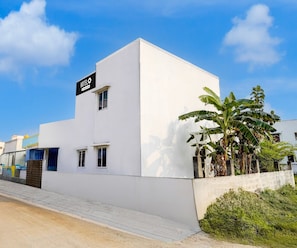 Un edificio moderno blanco con un letrero que dice 'HOTEL O' y un ventanal pequeño.