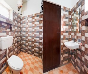 Baño con inodoro, lavabo y zona de ducha.