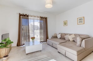 Ein modernes Wohnzimmer mit einer Couch, einem Couchtisch und einer Pflanze.