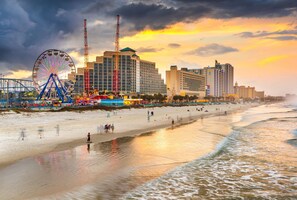 A coastal cityscape with a prominent Ferris wheel, high-rise buildings, and a beach. - Waterfront 1-bedroom apartment with AC in Palm Coast. Minutes to the beach. (Palm Coast)