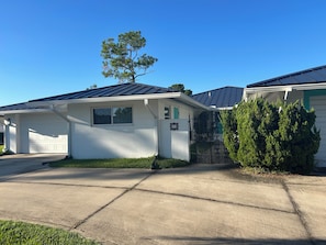 A residential property with a garage, a small front yard, and a metal gate. - Waterfront 1-bedroom apartment with AC in Palm Coast. Minutes to the beach. (Palm Coast)