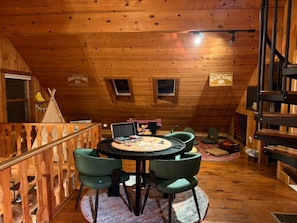 A cozy attic room with a wooden ceiling, a children's play area, and a bunk bed. - TheHiddenPond|Sauna|Hottub| Stargazing|Fishing|Ski (Windham)