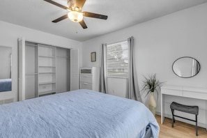 A bedroom with a bed, a desk, a chair, a wardrobe, and a ceiling fan. - Private Pool + Bar - Pet Friendly - Sleeps 6 (Port Orange)