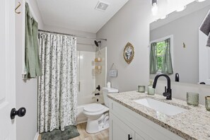 A bathroom with a shower, toilet, sink, and a mirror. - 3 B/2.5 BA, Pets OK, Fenced Backyard, Longer Stays OK, AT&T's fastest Wi-Fi (Gainesville)