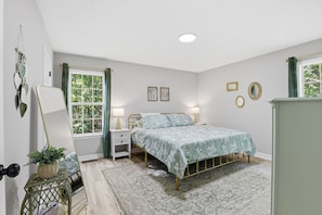 A bedroom with a bed, nightstands, a dresser, a window with curtains, and wall decorations. - 3 B/2.5 BA, Pets OK, Fenced Backyard, Longer Stays OK, AT&T's fastest Wi-Fi (Gainesville)