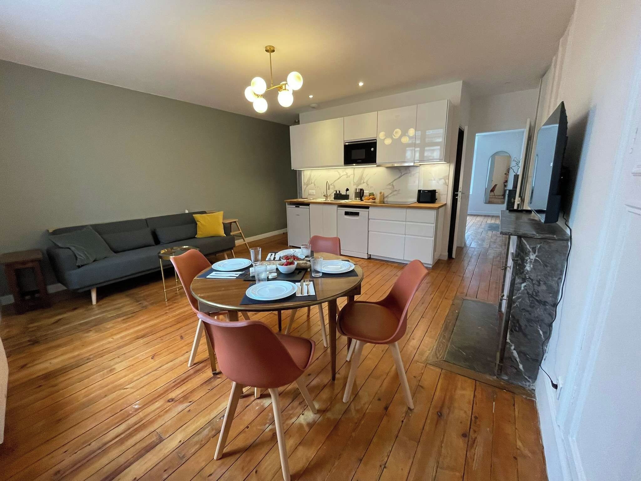 Un appartement moderne comprenant un coin repas, une cuisine et un espace de vie.