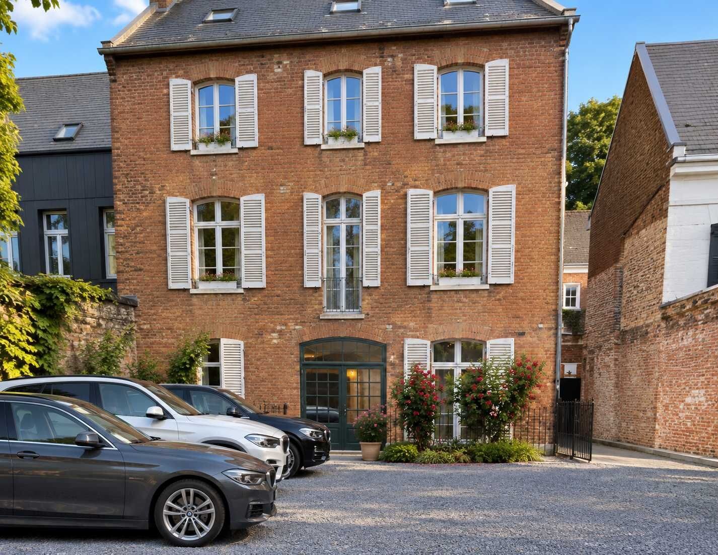 A brick building with multiple windows and a gated entrance.