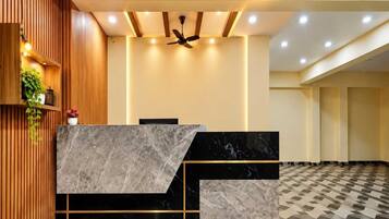 A reception desk with a marble top, a ceiling fan, recessed lighting, and a patterned floor.