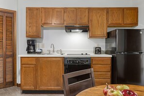 A kitchen with wooden cabinets, a stainless steel refrigerator, a dishwasher, and a coffee maker. - 1BR Blue Ridge Resort Condo · Indoor Pool, Hot Tub & Tennis · Sapphire NC (Sapphire)