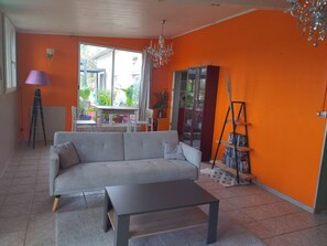 Ein Wohnzimmer mit einer Couch, einem Couchtisch, einem Bücherregal und einer Kristallleuchtre.