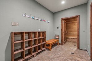 A hallway with wooden shelves, a bench, and a wooden door. - Remodeled 1BR · 5-Min Walk to Ski · Pool, Hot Tub, Sauna & Golf Views (Park City)