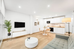 A modern living room with a flat-screen TV, a round coffee table, and a grey sofa. - La Carihuela Seafront (Torremolinos)