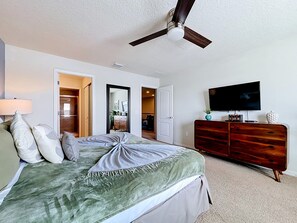 A bedroom with a bed, a dresser, a television, and a ceiling fan. - Disney 5BR Home, Private Pool, Water Slides (Kissimmee)