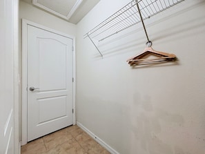 A hallway with a white door, a ceiling fan, and a clothes drying rack. - Disney 5BR Home, Private Pool, Water Slides (Kissimmee)
