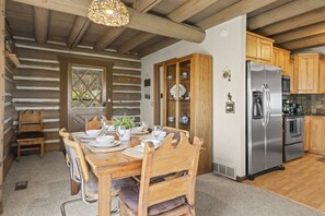 A wooden dining table set with plates, glasses, and a potted plant. - Private Hot Tub · Sleeps 10 · Under a 5-Minute Walk to Silver Star Lift (Park City)