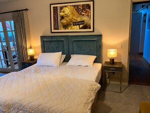 A hotel room with a large bed, two bedside tables with lamps, a framed picture of a lion, and a view of the outside through a window with curtains. - The Wellington Bed & Breakfast in the heart of Yorkshire (Richmond)
