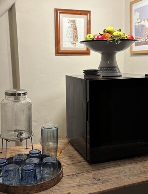 A kitchen counter with a fruit bowl, a glass jar, and a tray of blue glasses. - The Wellington Bed & Breakfast in the heart of Yorkshire (Richmond)