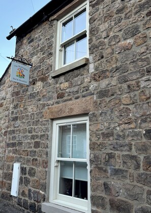 A stone building with a sign indicating it offers bed and breakfast services. - The Wellington Bed & Breakfast in the heart of Yorkshire (Richmond)