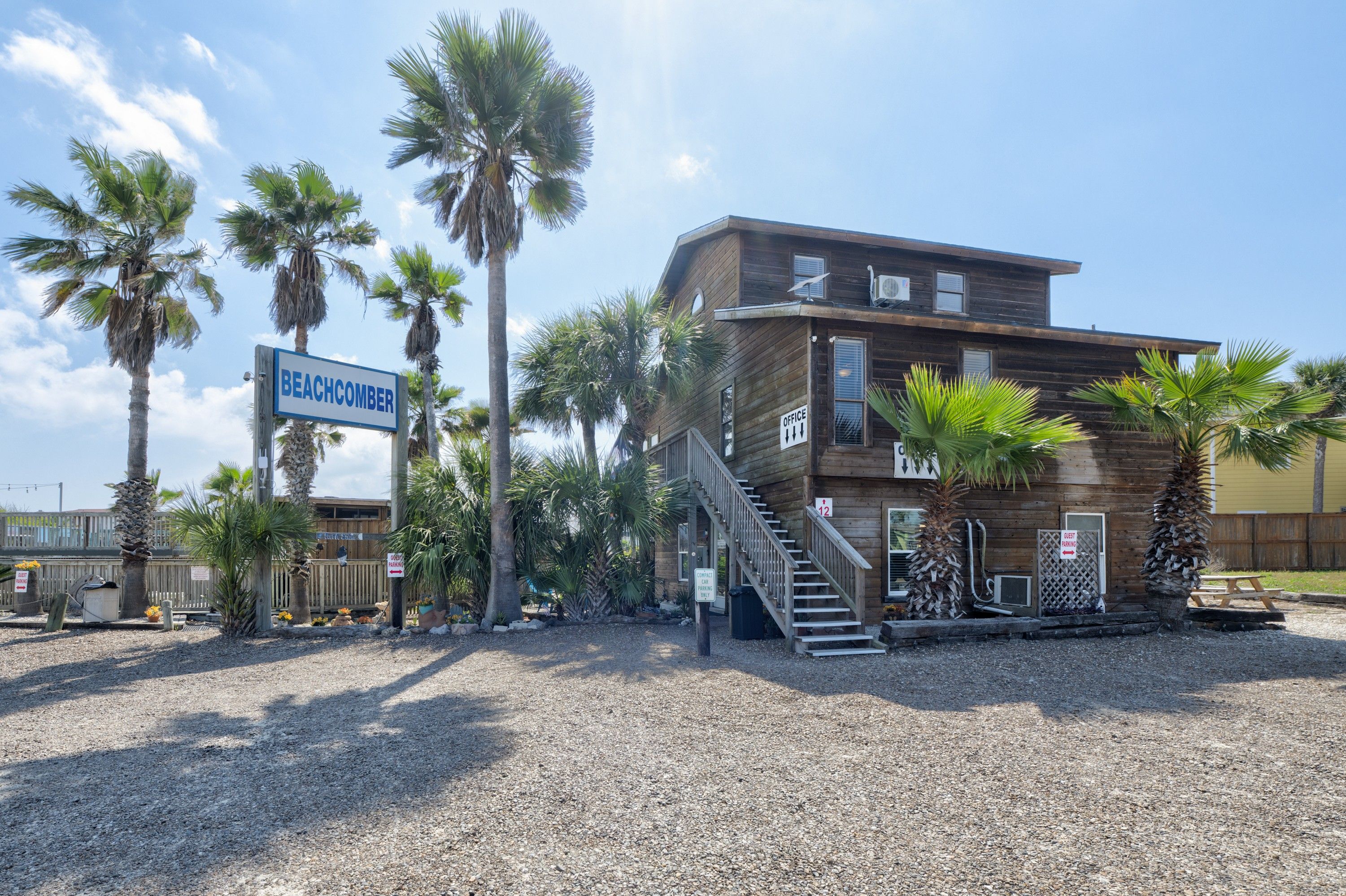 A wooden building with a sign reading 'BEACHCOMBER' and a staircase leading to the entrance.