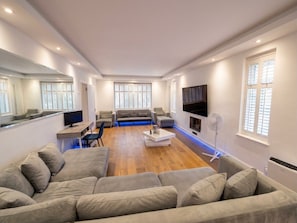 A modern living room with a sofa, a coffee table, and a TV. - Peaceful bedroom house in welcoming London neighborhood (London)
