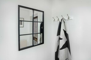 Ein Badezimmer mit Spiegel, Handtuchhalter und einem aufgehängten Handtuch.