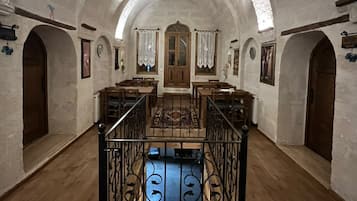 A spacious interior with arched ceilings, wooden furniture, and a central staircase.