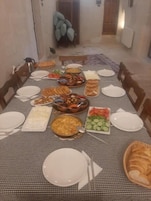 A dining table set for a meal with various dishes and bread.