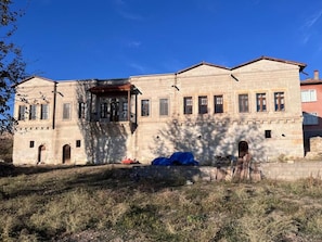 Un bâtiment à deux étages, doté d’une façade en pierre, de nombreuses fenêtres et d’un toit plat.