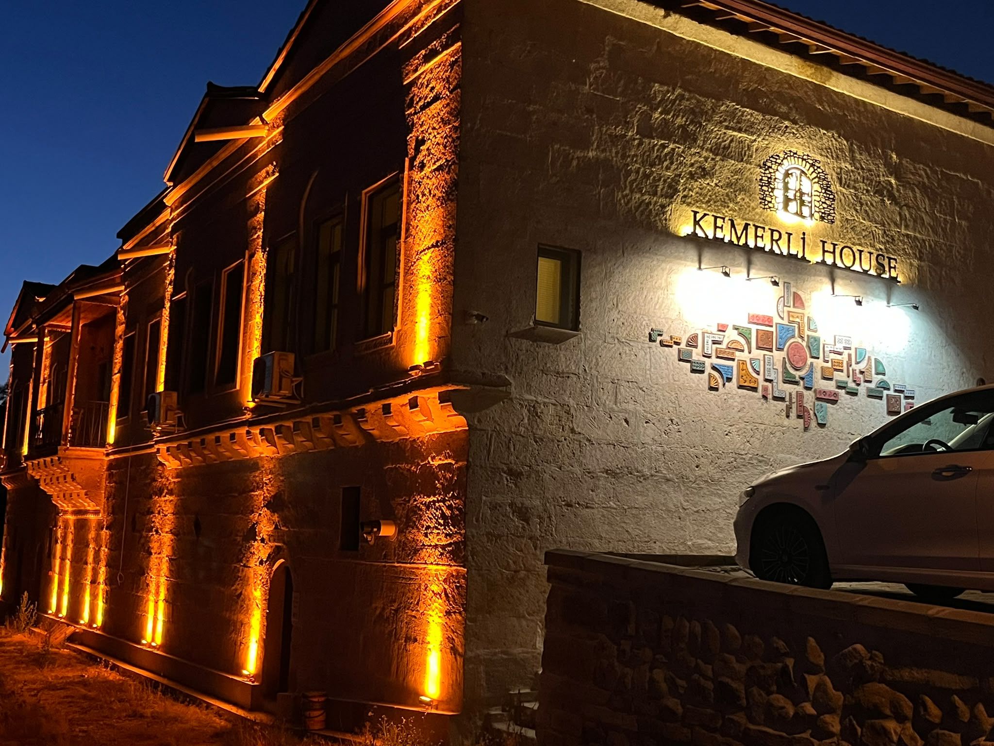 A building with a sign reading 'KEMERI HOUSE' and a car parked in front.