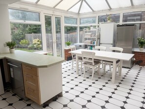 A conservatory with a dining area, a built-in kitchen, and a view of the garden. - Adorable bedroom house in wonderful Thornton Heath neighborhood (Thornton Heath)